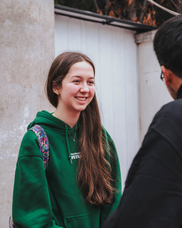 Joven con polerón de la Juventud Republicana conversando en una actividad.